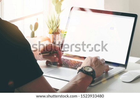 Cropped image of man using laptop at home office with sunlight in the morning. Working at home concept.