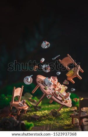 Tiny furniture in a forest. Doll tea party with cake and coffee. Alice in Wonderland concept.