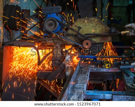 A blurred out of focus Worker is cutting stainless steel.  Industrial steel welder in factory technical