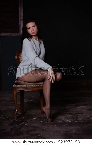 brunette sitting on a chair in a sweater