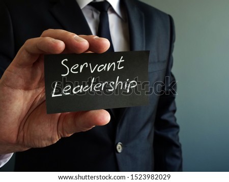 Servant leadership concept. Black piece of paper in the hands. Royalty-Free Stock Photo #1523982029