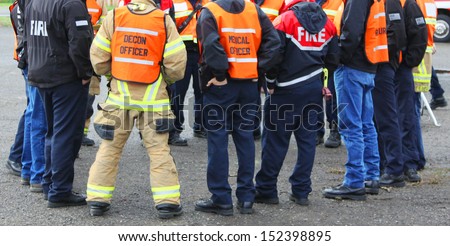 In any urban area the fire departments and emergency response teams will conduct disaster preparedness drills. This group of team members gathers around to discuss options. Royalty-Free Stock Photo #152398895