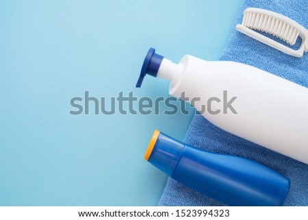 White shampoo bottle, baby soap, comb, towel, blue sunscreen bottle. Natural organic bath products. Bathroom items. Flat lay stock photo for web site and beauty blog.