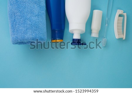 White shampoo bottle, baby soap, comb, towel, blue sunscreen bottle. Natural organic bath products. Bathroom items. Flat lay stock photo for web site and beauty blog.