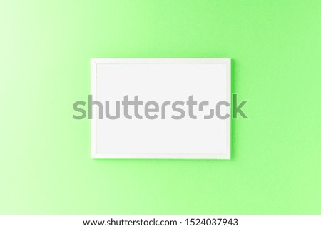 Empty picture frame on green wall. Mockup with copyspace