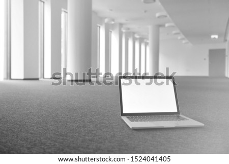 Black and white photo of laptop on the floor