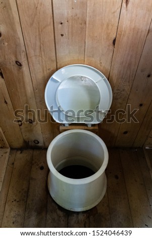 Rustic Latrine with hole in toilet in the middle of the woods, Gatineau Park ,Quebec, Canada.
