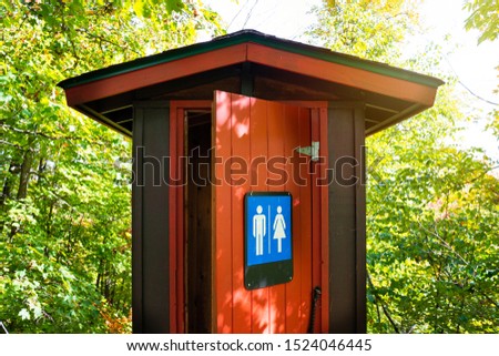 Gorgeous red and brown public toilet in the middle of the woods, Gatineau Park ,Quebec, Canada.