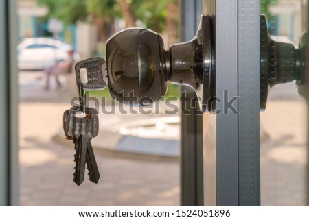 Key in the door lock with blurry outdoor background, selective focus