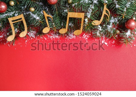 Flat lay composition with Christmas decor and music notes on red background, space for text