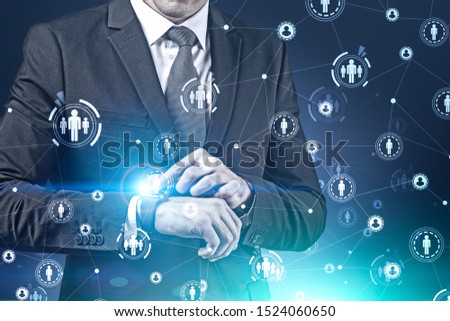 Businessman using smartwatch over blue background with double exposure of HUD HR interface. Concept of technology and social connection in business. Toned image