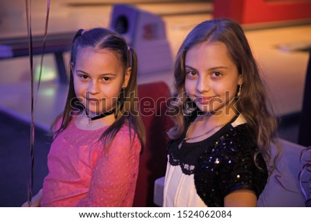 Girls best friends celebrate birthday in bowling club. Ideas how to celebrate birthday for teens. Girls cute smiling children enjoy birthday party lighted with blue light. Birthday party at bowling.