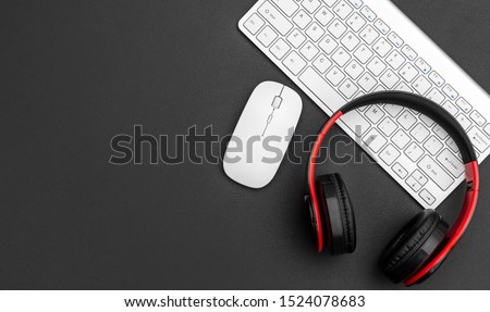 Headphones with computer keyboard and computer mouse on black. Top view. Space for text. Royalty-Free Stock Photo #1524078683