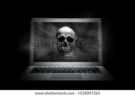 Human skull on laptop screen over black background
