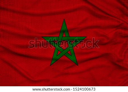 photo of the beautiful colored national flag of the state of Morocco on textured fabric, concept of tourism, economics and politics, closeup