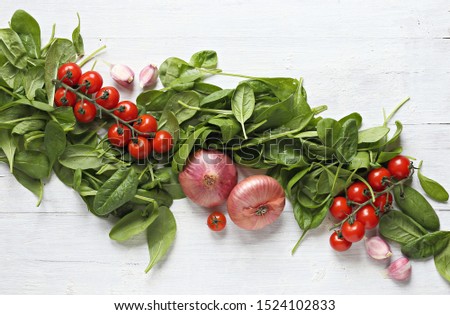 Vegetables ingredients composition. Spinach, tomatoes and red onion . Overhead view