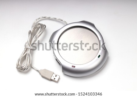 electronic usb hub and heater for cup coffee or tea at office. digital usb warmer device on grey background. 