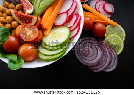 Close up view of a Buddha bowl with seasonal ingredients on black background. 