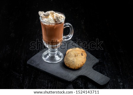 Chocolate dessert, hot chocolate with slices of ice cream, two livers lie nearby. In a beautiful glass on a black slate. 45 view.