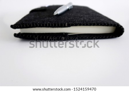 Black professional notebook and silver pen - concept of getting fresh idea - make a write down note  or meeting with cllent