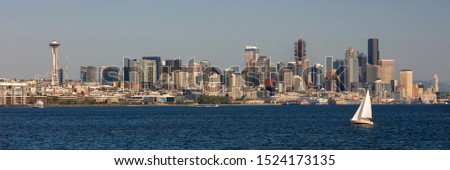 Panoramic web banner of yacht sailboat sail boat sailing in front of the Seattle city skyline in golden evening light taken from Puget Sound, Wshington State, USA panorama.