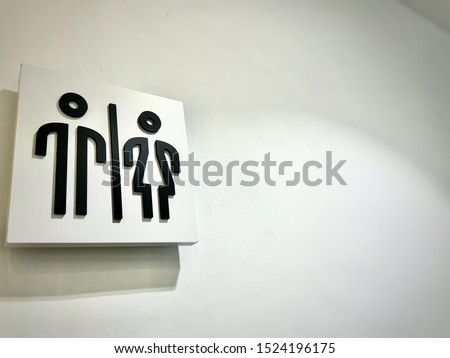 Toilet sign with white wall background.
