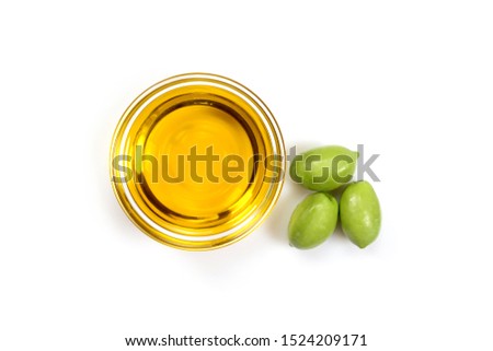 Olive oil. Greek olive oil in glass transparent bowl with three green olives. Close up, Isolated on white background.