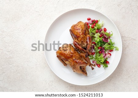 Whole roasted quail on white plate, top view, copy space