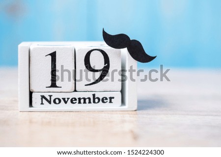 19 November Calendar and mustache on wood table background. Father, International men day, Prostate Cancer Awareness and World cancer day concept
