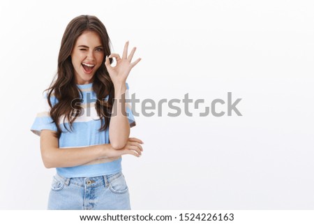 Excellent choice, approve it. Confident attractive european woman with curly haircut wink flirty say alright, show okay ok sign, judging friends choice good pick, satisfied and recommend service