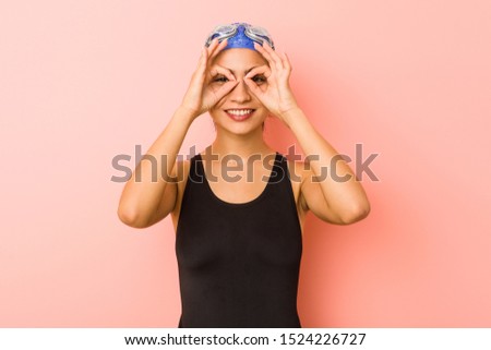 Young arab swimmer woman isolated showing okay sign over eyes