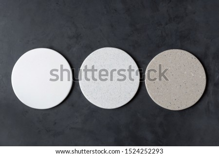 Round coasters made of artificial stone tabletop on a black background.  Food stand. Royalty-Free Stock Photo #1524252293