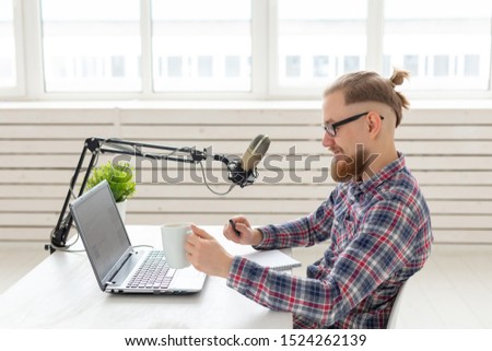 blogger, streamer and broadcasting concept - young man DJ working on the radio.
