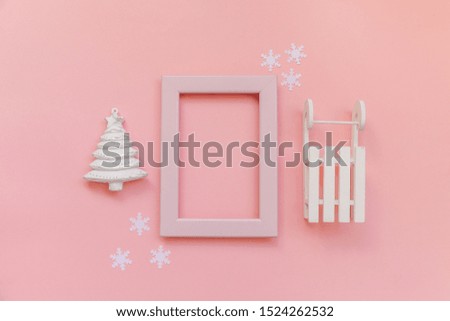 Simply minimal composition winter objects pink frame ornament fir tree sled isolated on pink pastel background. Christmas New Year december time for celebration concept. Flat lay top view mock up