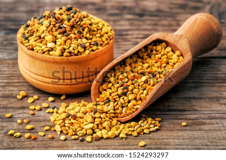 healthy bee pollen grains on wooden background Royalty-Free Stock Photo #1524293297
