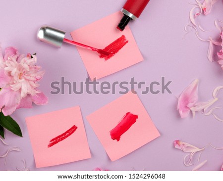 liquid lipstick and a smear of red lipstick on a pink paper sticker, purple background