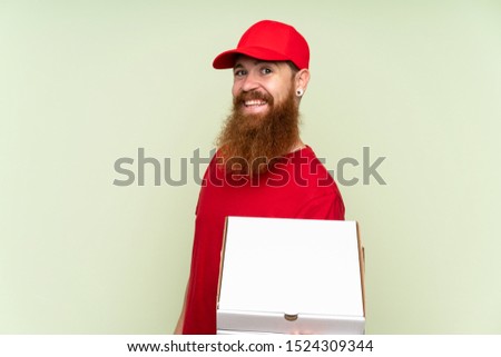 Delivery man with long beard over isolated green background smiling a lot
