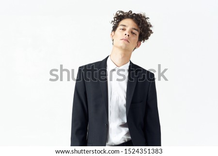 A man in a white shirt and in a black jacket curly hair business finance isolated background                               
