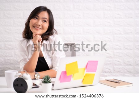 Happy woman sitting at home office working using computer laptop