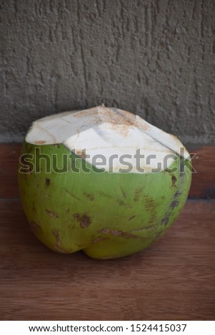 Green colored fresh coconut with a visible rough background