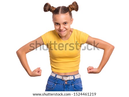 Portrait of funny teen girl raised her hands and shows biceps, isolated on white background. Serious cute teenage young boy shows biceps. Strong child flexing biceps.
