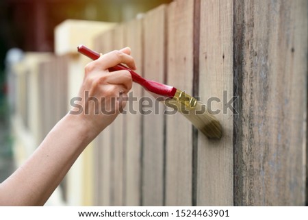 Applying protective varnish on a wooden fence, diy concept
