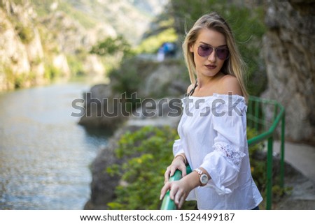 Beautiful young girl enjoying her day off in the outdoors canyon side by hiking and posing and being happy