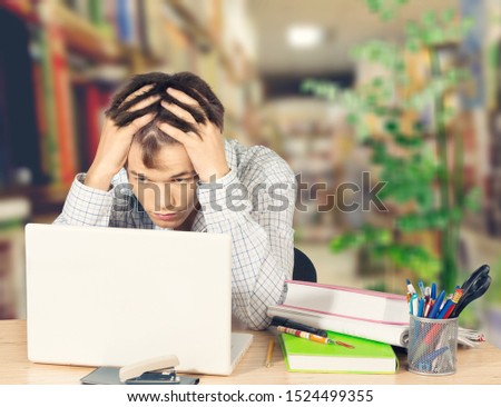 Frustrated black male student work at laptop get mad having device software operational problems, angry african American guy man feel confused with slow internet connection on computer or virus attack Royalty-Free Stock Photo #1524499355
