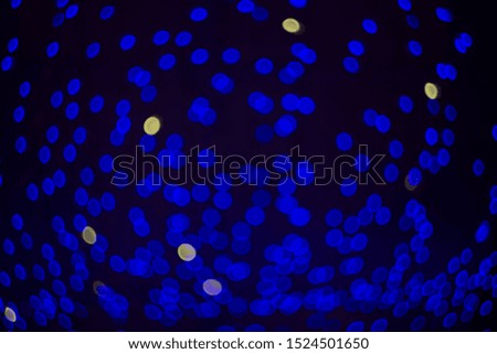 Fabulous bokeh of circles of blue on a dark background. Uniform filling of the frame. Horizontal.