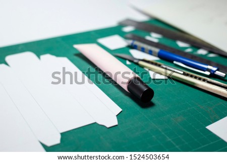Product or packaging design and development template boxes design artwork on cutting board with tools. Handcraft design template cosmetic box with equipment such as cutter knife, ruler, pencil.
