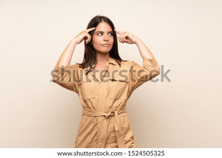 Young girl over isolated background having doubts and thinking