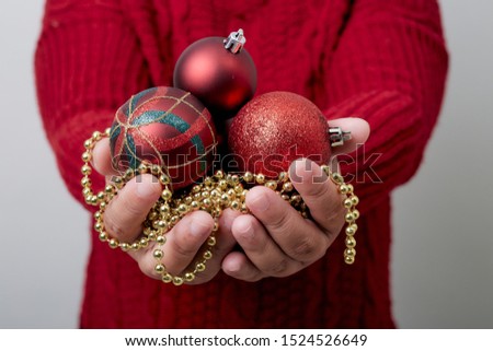 Female hands holding a Christmas balls bright gray background