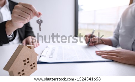 estate agent giving house keys present price for loan investment to home ownership for buy house contract. 