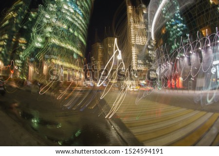 Long exposure photography of traffic on city street in the business district. Rush hour in city in autumn night. Defocused business buildings. Fish-Eye lens